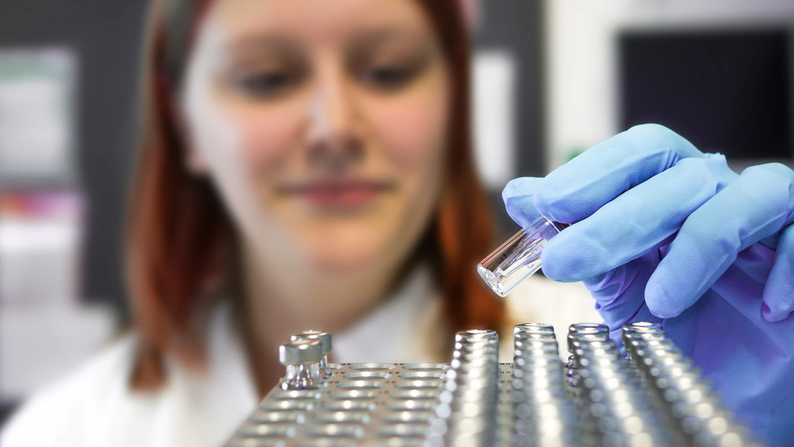 A researcher in a white coat in a laboratory.