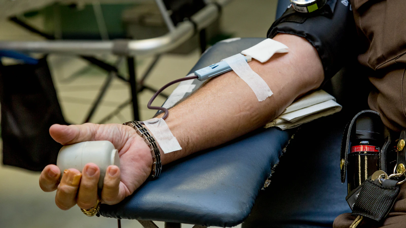 A person has blood drawn from their arm at a collection point.