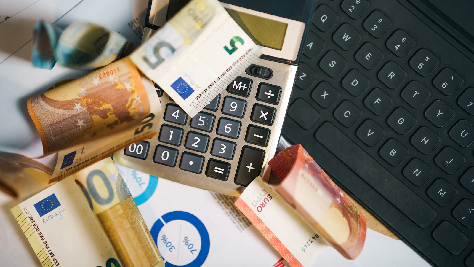 A calculator sitting on top of a pile of money.