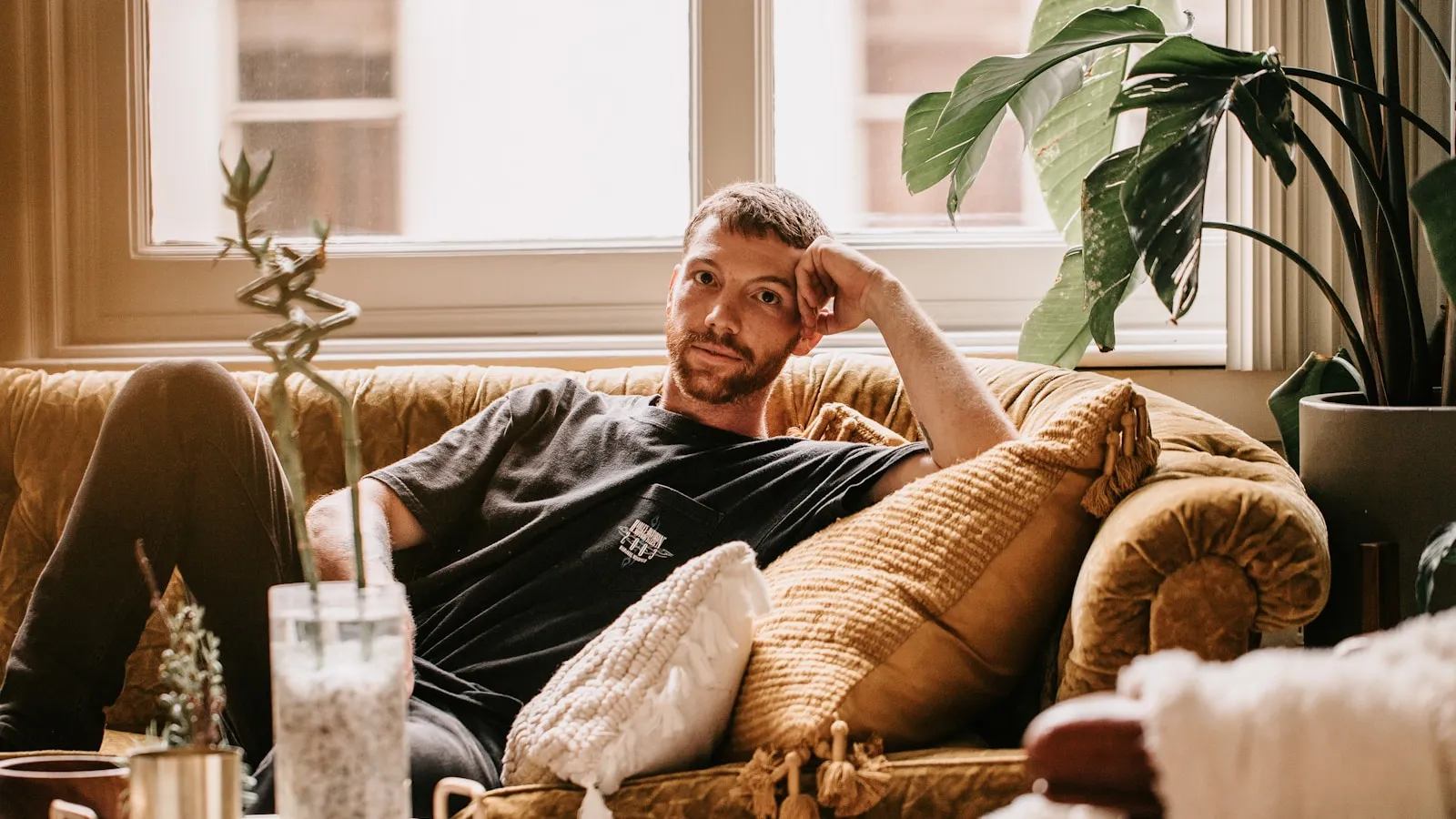 Man van middelbare leeftijd rust op de bank, als beeld bij coeliakie op latere leeftijd.