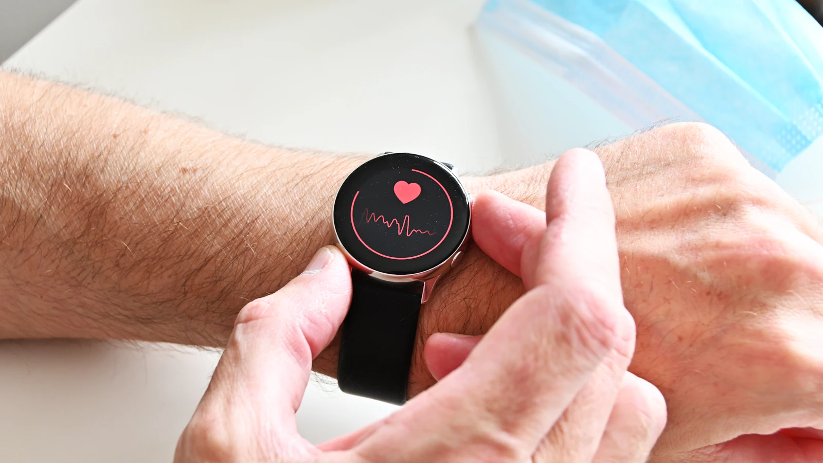 Iemand bekijkt de hartslagmeting op een smartwatch om de pols.