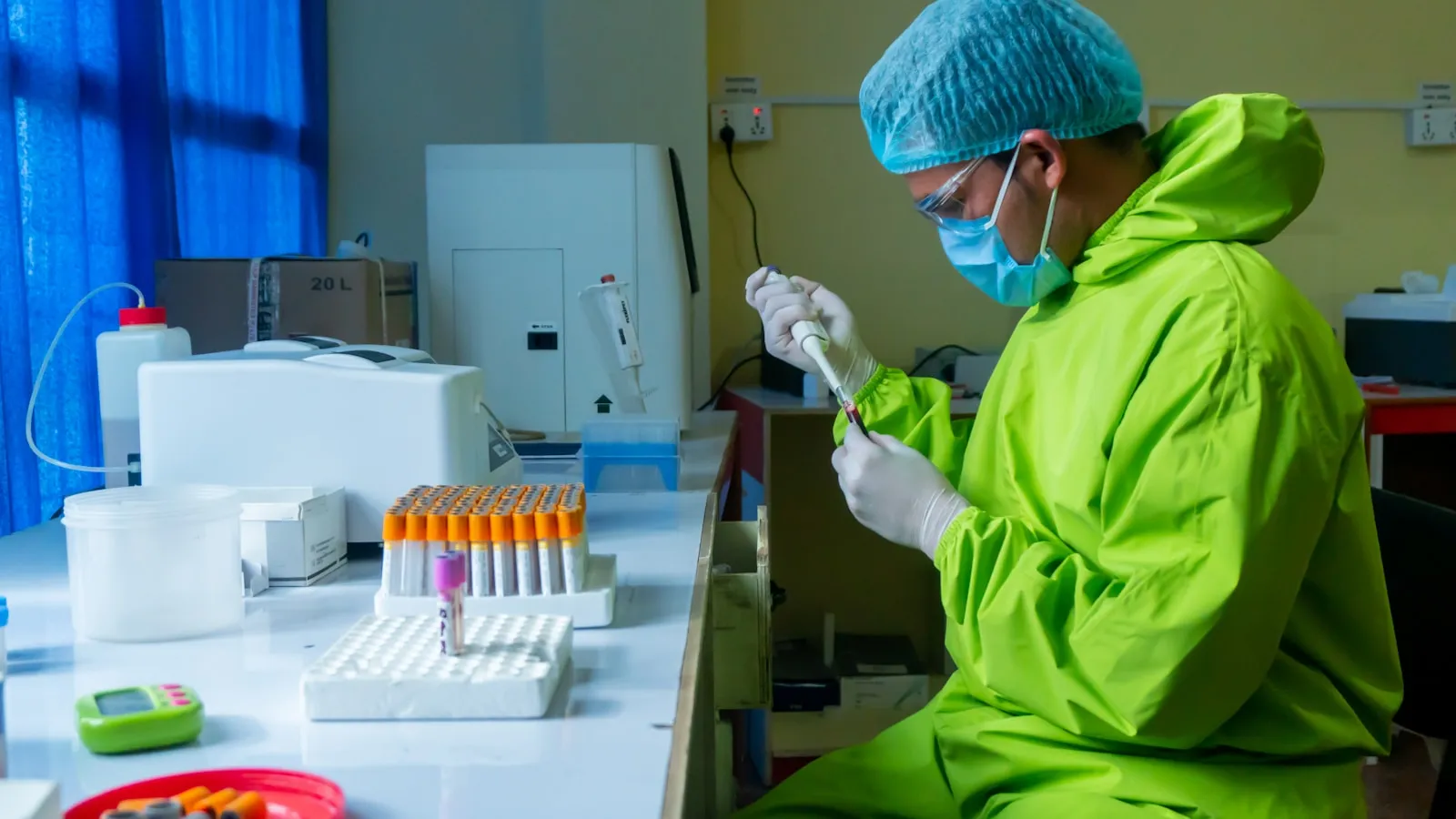 Een laboratoriummedewerker onderzoekt een buisje bloed.