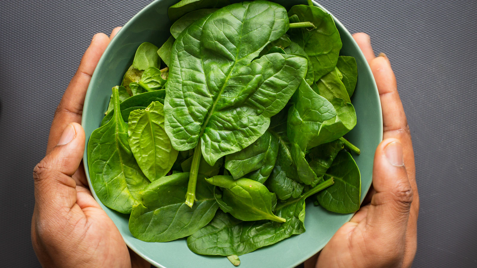 Fresh leafy greens in a bowl, a natural source of folate.