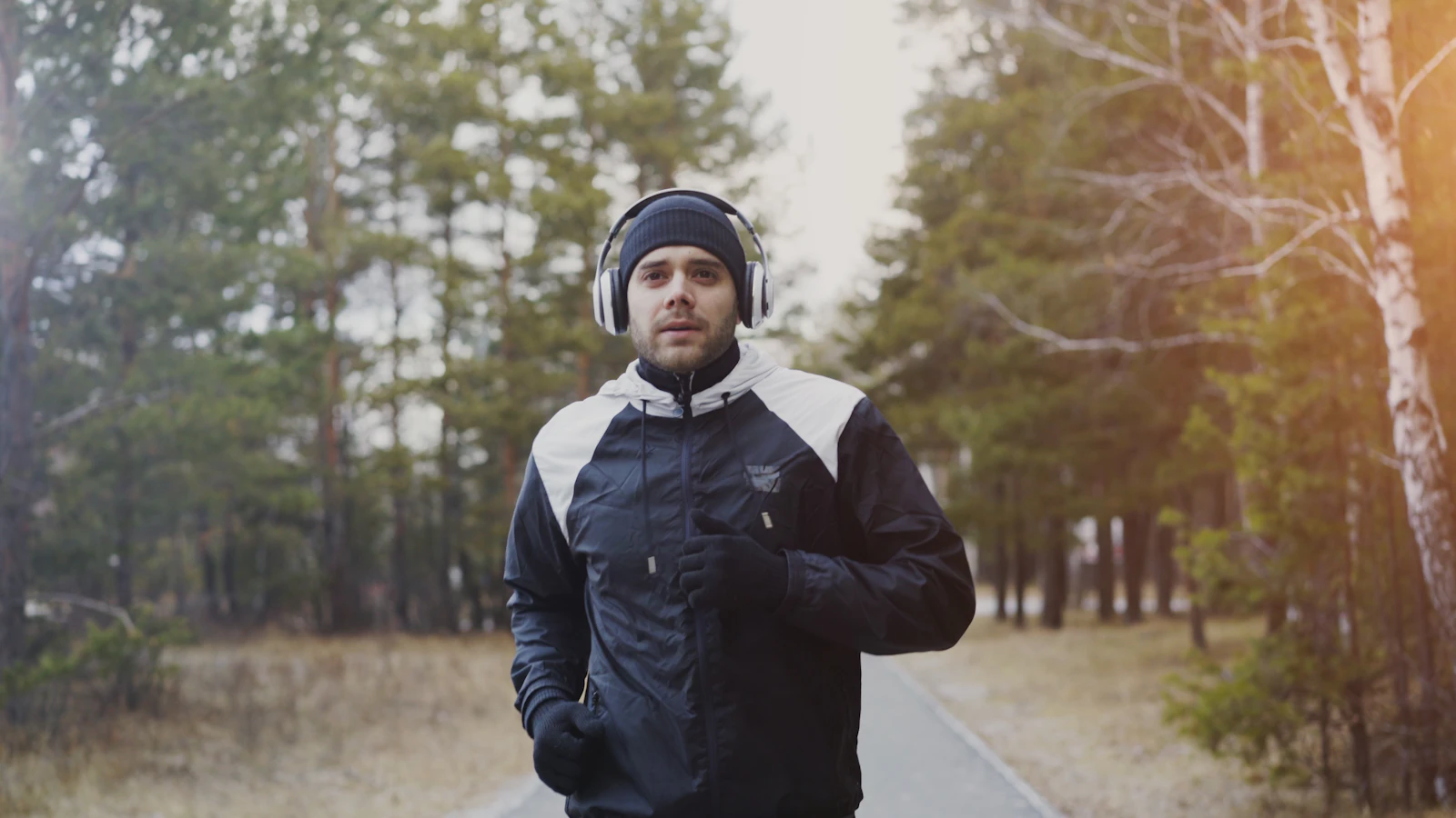 A man runs outdoors wearing headphones.