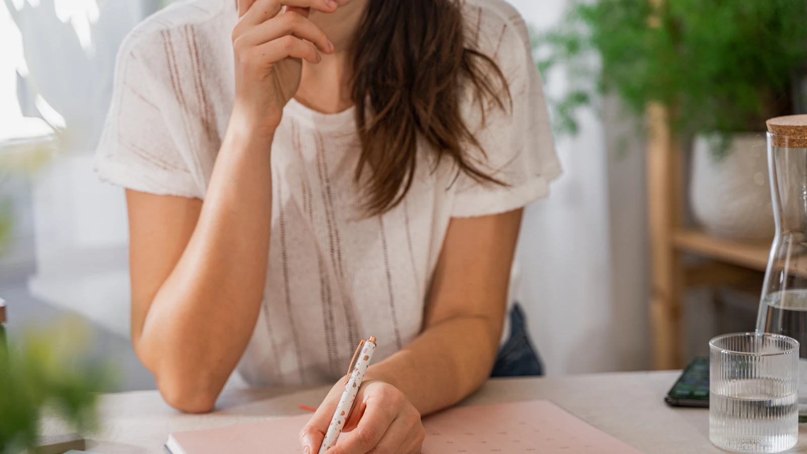 Vrouw houdt haar cyclus bij in een agenda, als beeld bij het herkennen van perimenopauze.