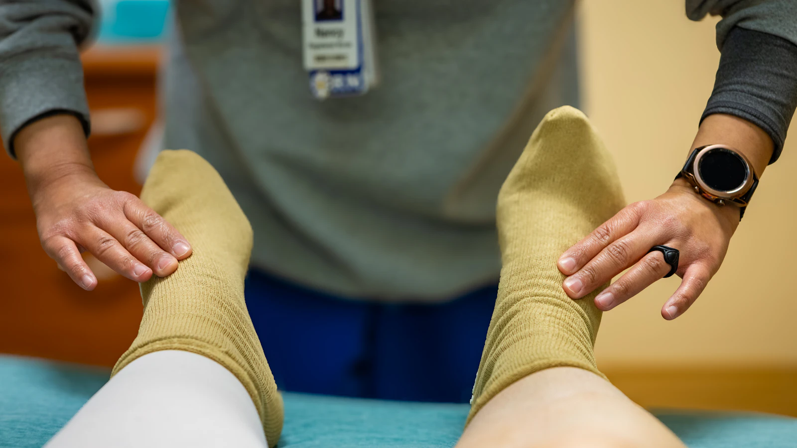 Een zorgverlener onderzoekt de voeten en enkels van een patient.