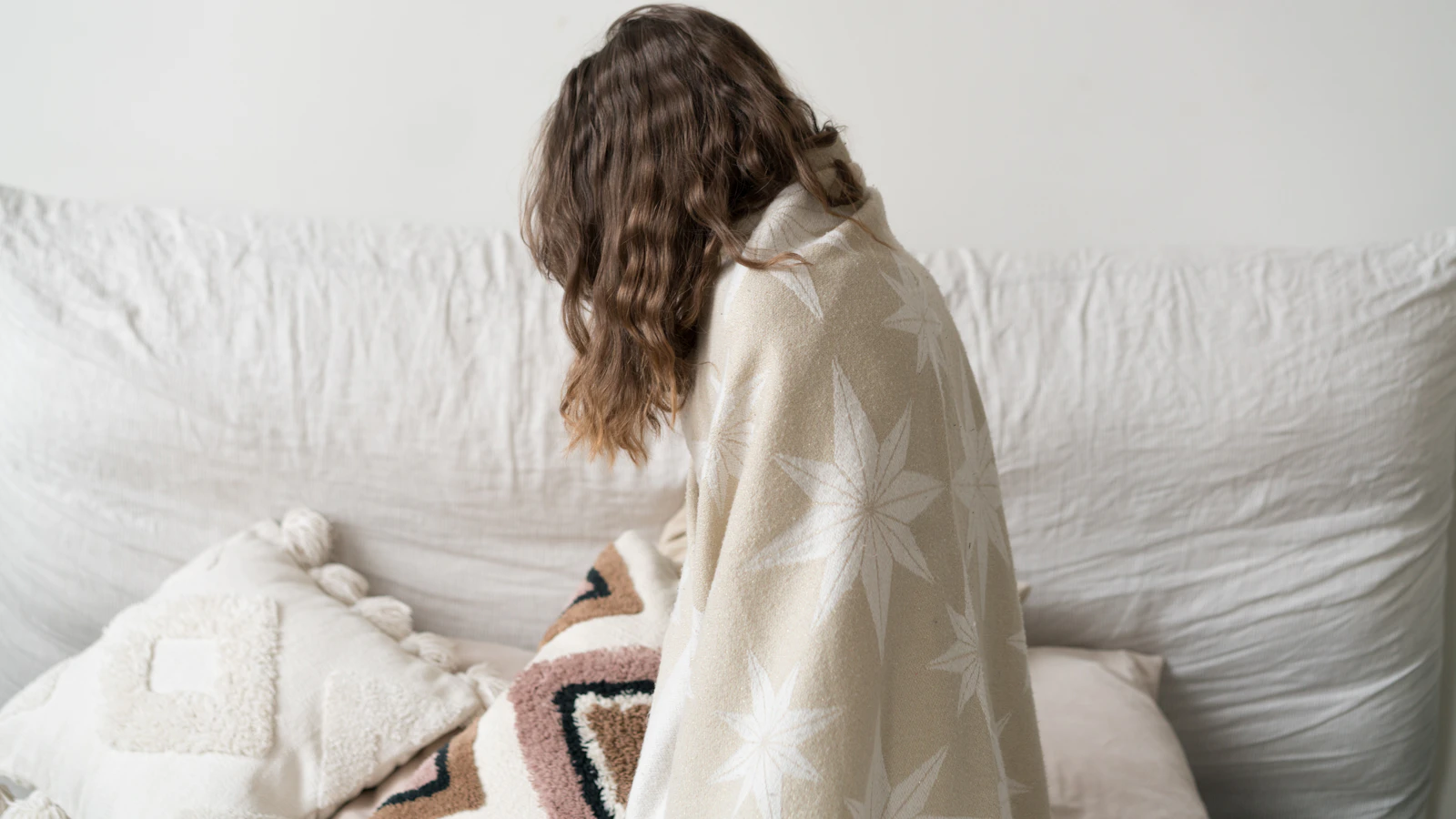 Vrouw met een deken om zich heen, kouwelijk door een mogelijk trage schildklier.