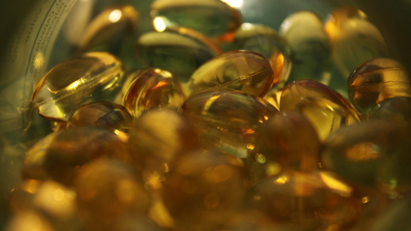 Gele vitamine D-capsules in een schaaltje als supplement.
