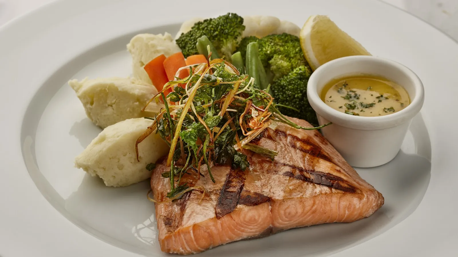 Gegrilde zalmfilet met groenten op een bord.
