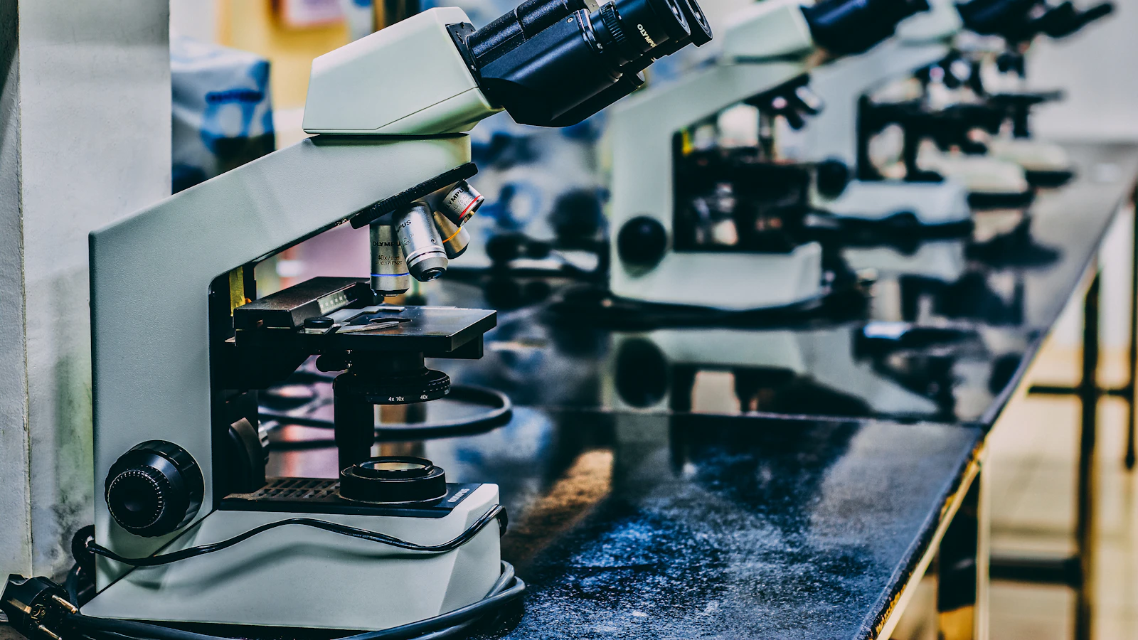 A white microscope on a laboratory table.